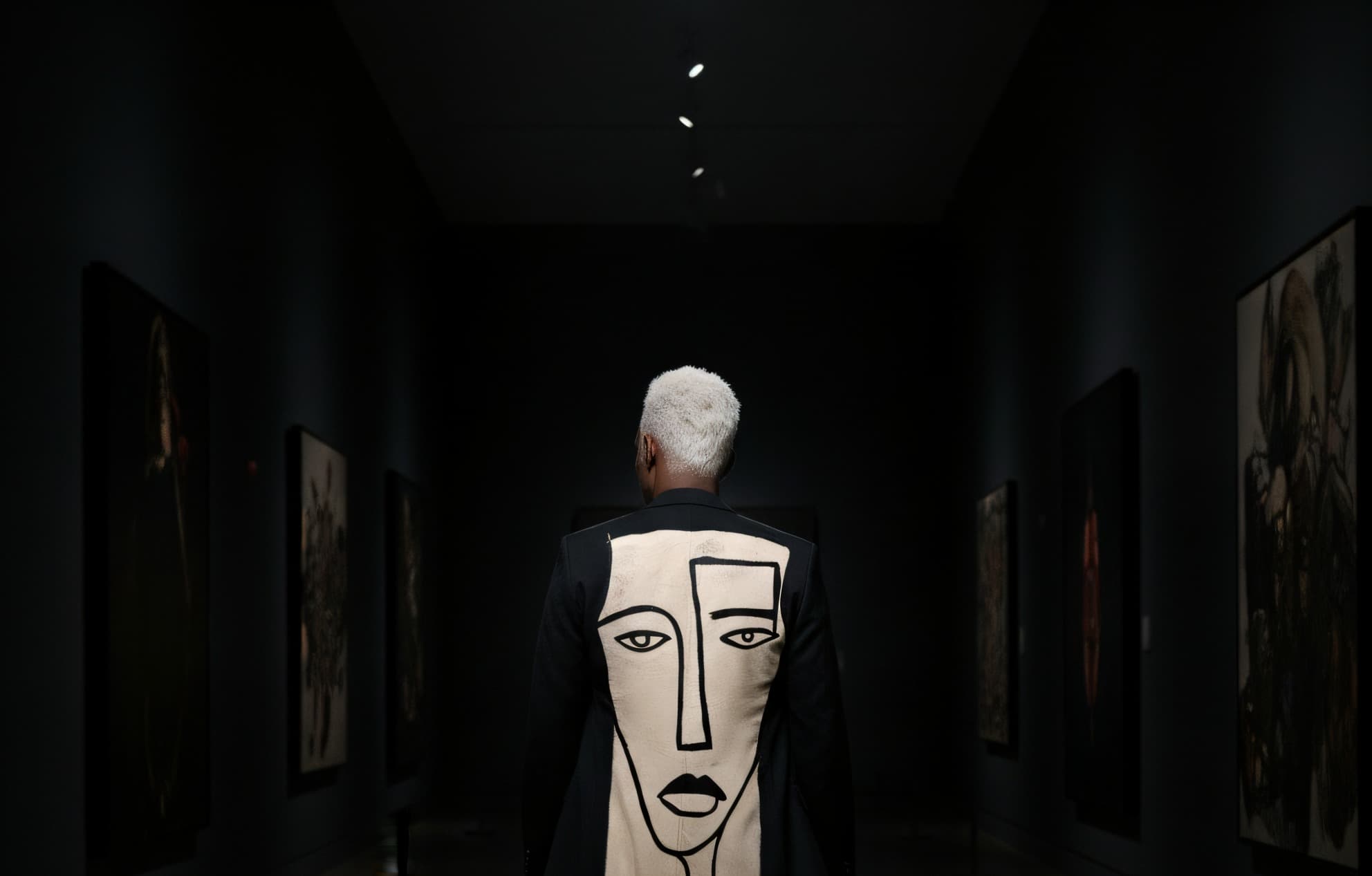 MOSE.ART editorial, the painted MOSE.ART face on the back of a long coat, framed tighter and shifted toward the right side